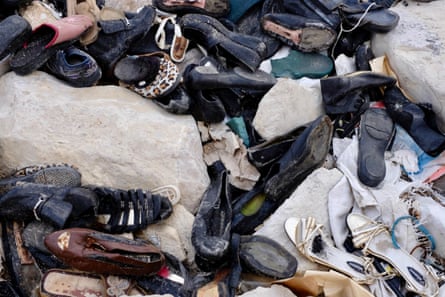 A pile of shoes washed up on a beach