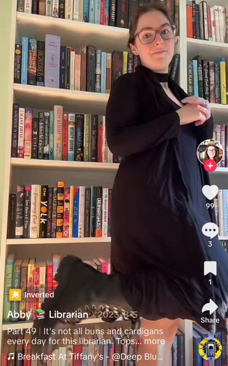 woman stands in front of bookshelf