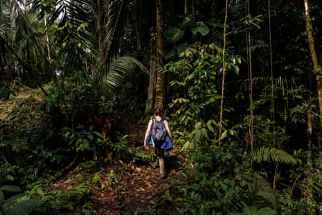 Mandie Quark wearing wellies and a backpack hikes through the Amazon rainforest in Ecuador.