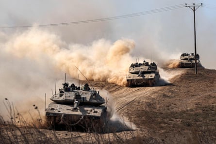 Israeli army Merkava battle tanks deploy along the border with the Gaza Strip in southern Israel on 13 October 2023.