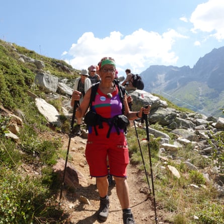 Rita Schirmer-Braun walks on a mountain path, followed by other walkers.