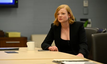 White woman wearing black jacket sits at a table.