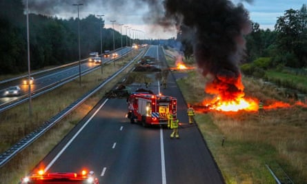 Firefighters at the scene as farmers set fire to manure and hay bales during a protest in Apeldoorn, the Netherlands in July 2022