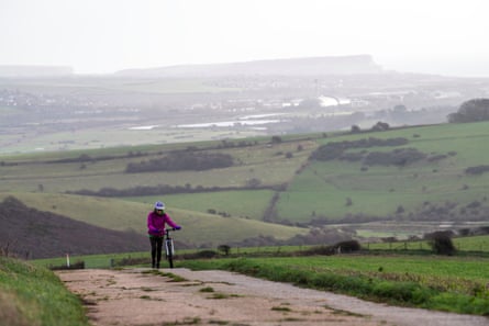 A cyclist on South Downs Way path, with Newhaven in the background.