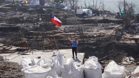 Andrea Jaramillo, 48, talks on the phone under a Chilean flag on the land where her home used to stand in the Achupalla neighbourhood of Viña del Mar
