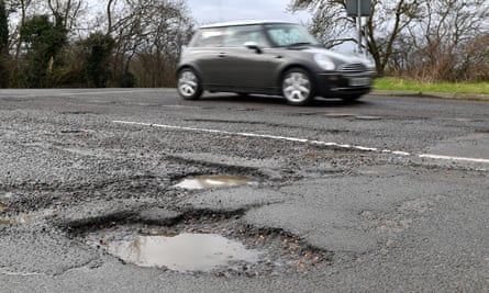 A car passing potholes in a road near Peterborough
