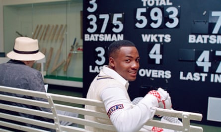 Brian Lara, wearing his Warwickshire kit, poses in front of a scoreboard showing his record Test score of 375 in the museum at Lord’s.