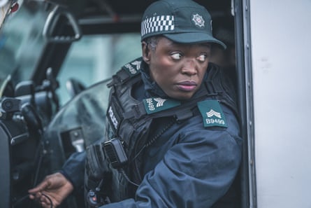Andi Osho as Sandra Cliff inside a police vehicle