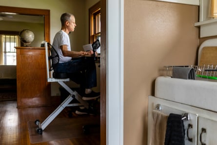 man sits in office, working on desk, seen from the opposite side as compared with the photo above
