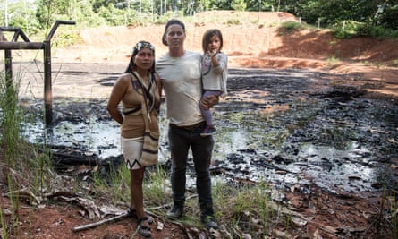 Nenquimo and Anderson with their daughter Daime beside a toxic waste pit of crude oil in the northern Ecuadorian Amazon.