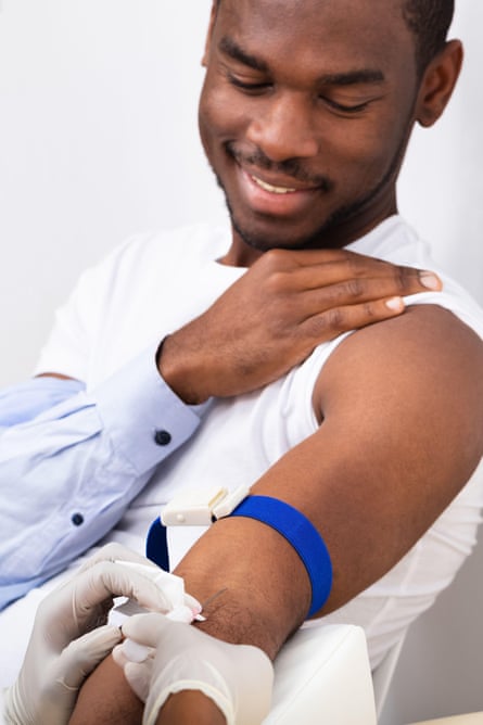 a man with his sleeve rolled having a blood test