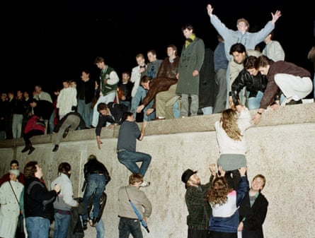 East and West Germans climb the wall on 9 November 1989.