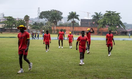Uganda players leave the field after rain cuts pre-tournament practice short in Kampala.
