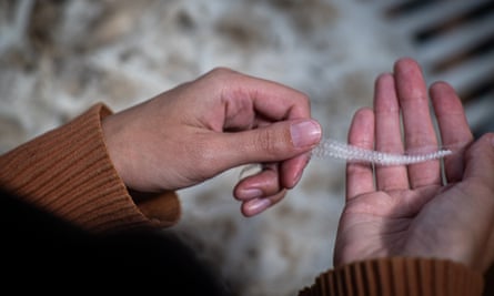 A person holding a strand of wool in their hands 