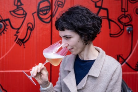 Paola Ferraro holds a large glass of sparkling wine to her nose