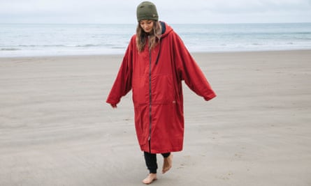 A woman on a beach wearing a dryrobe