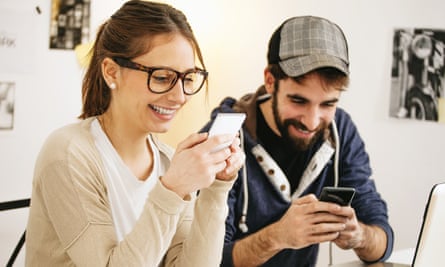 Young couple with smartphones at modern home office