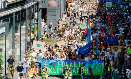 A high-up view of a protest march. People are holding flags, banners and homemade signs