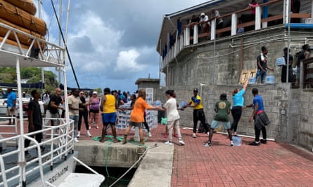 People stand in line helping to put vital supplies on a boat